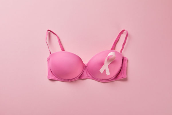 Hand holding red bra in consept of breast awareness. Brassiere