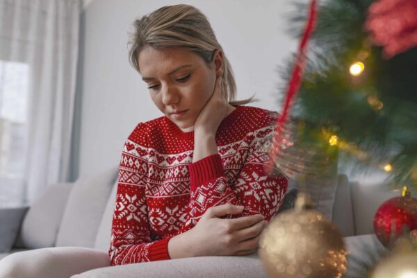 Festive brunette feeling sad at christmas looking up. Christmas
