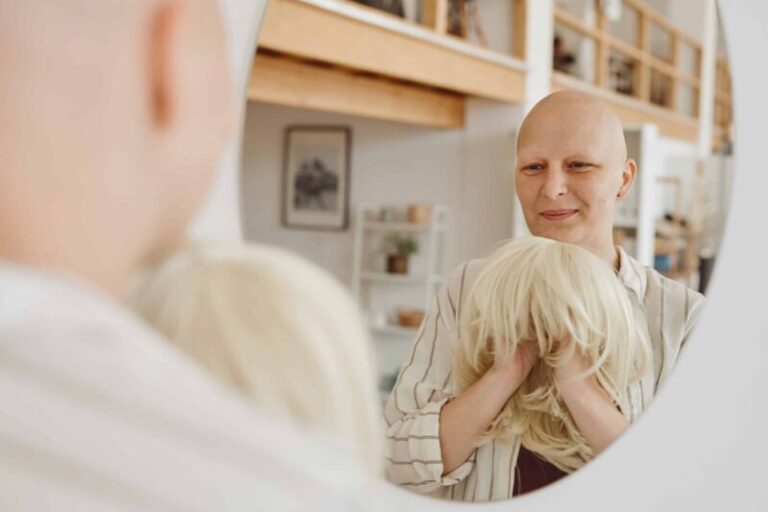 Bald Woman Smiling at Mirror Winter Wig Care